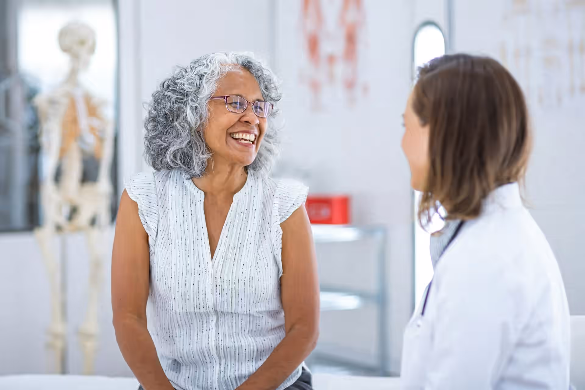 elderly patient smiling during a conversation with her doctor in a medical office